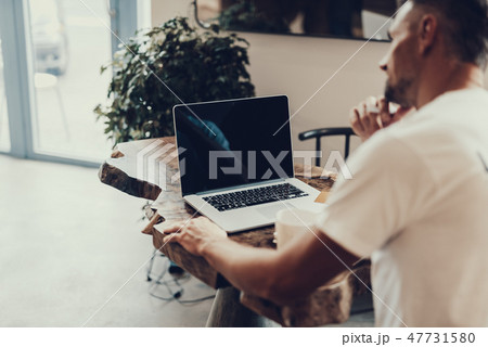 Laptop with empty monitor standing near blurred man 47731580