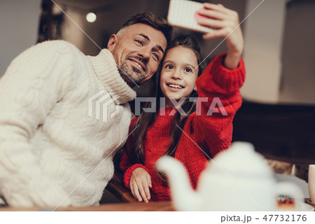 Father and daughter taking photo on cellular 47732176