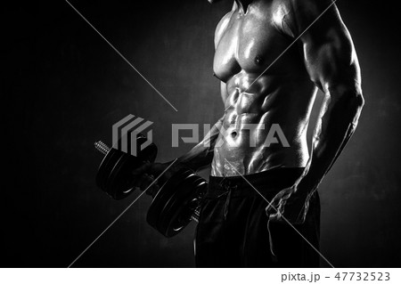 Athletic shirtless young male fitness model makes exercises 47732523