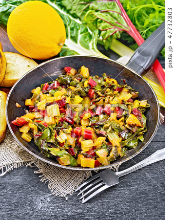 Mangold braised in pan on wooden board 47732803