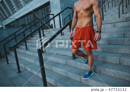 Stripped to waist sportman going down at street Stripped to waist sportman going down at street 47733132