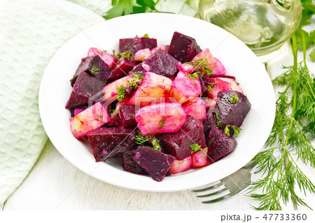 Salad of beets and potato in plate on wooden board 47733360