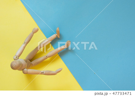 Wooden doll on yellow and blue. Concept beach sand and water. 47733471