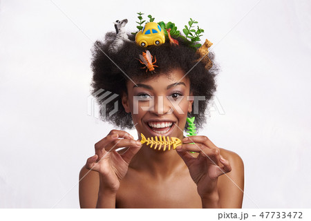 Cheerful model hold fish skeleton earring in hands Cheerful model hold fish skeleton earring in hands 47733472