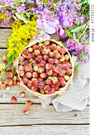 Strawberries in box with flowers on board top 47733772