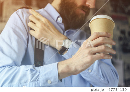 Businessman in blue shirt drinks coffee 47734139