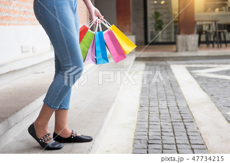 consumerism woman holding many shopping bags in fashion boutique consumerism woman holding many shopping bags in fashion boutique 47734215