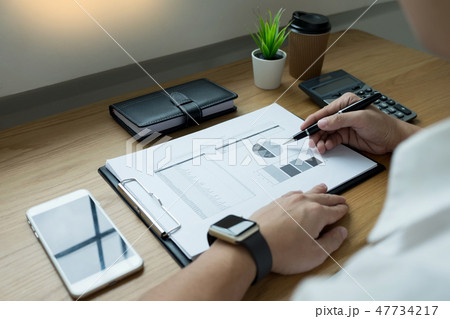businessman going through some paperwork and signing a document businessman going through some paperwork and signing a document 47734217