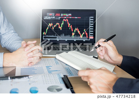 Stock traders looking at finance analysis marketing report tradi Stock traders looking at finance analysis marketing report tradi 47734218