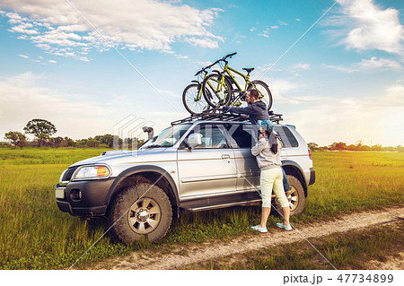 Couple taking off their bicycles from roof rack Couple taking off their bicycles from roof rack 47734899