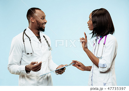 The female and male happy afro american doctors on blue background 47735397