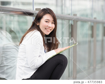 黄緑色のファイルを持つビジネスウーマン 黄緑色のファイルを持つビジネスウーマン 47735983