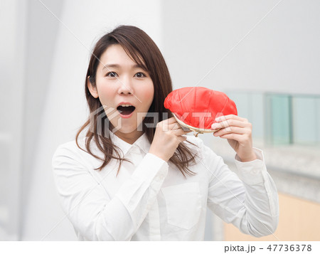 赤い財布を持って驚く女性 47736378