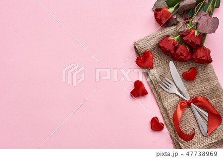 Romantic dinner. Close up of table setting with fresh red roses and decorative hearts 47738969