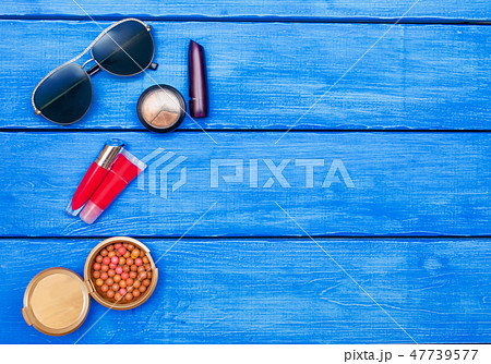 Makeup products on blue wood background Makeup products on blue wood background 47739577