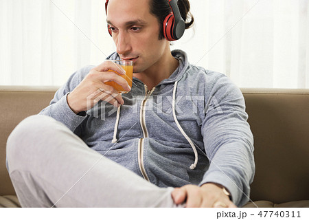 Man with juice resting at home 47740311