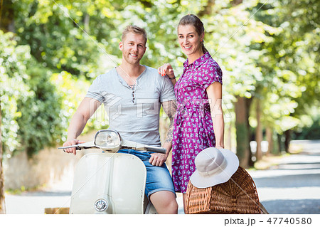 Young couple with scooter and picnic basket 47740580