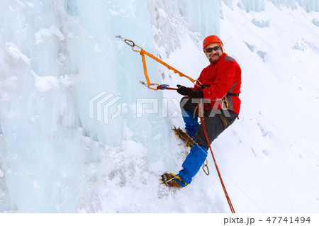 ice climber on a frozen waterfall ice climber on a frozen waterfall 47741494