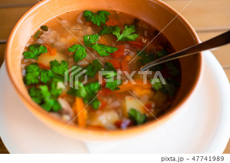 Clay plate with ear soup with a spoon Clay plate with ear soup with a spoon 47741989