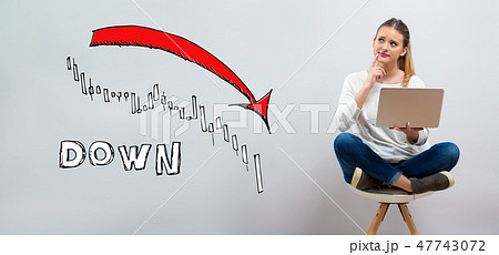 Market down trend chart with young woman using her laptop Market down trend chart with young woman using her laptop 47743072
