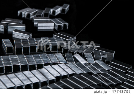 Many metallic refills staples on black work desk Many metallic refills staples on black work desk 47743735