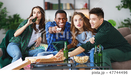 group of happy friends fans watching a match on tv 47744496