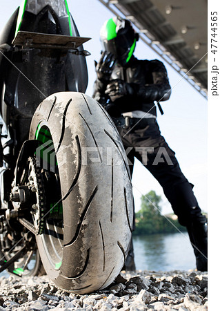 Biker man and motorcycle with river background, Rider moto trip on the street at the riverside Biker man and motorcycle with river background, Rider moto trip on the street at the riverside 47744565