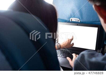 Rear view working on laptop on airplane 47746609