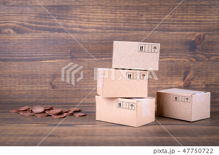 Paper boxes and cash coins on wooden background Paper boxes and cash coins on wooden background 47750722