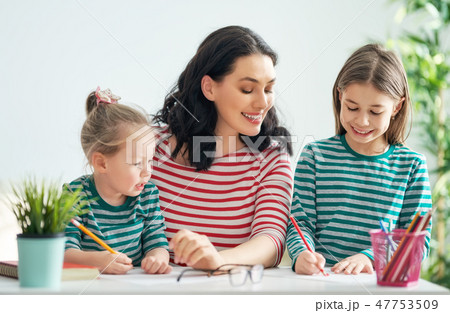 Mother and daughters drawing together Mother and daughters drawing together 47753509