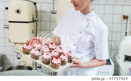 Baker women in pastry bakery working on muffins Baker women in pastry bakery working on muffins 47757424