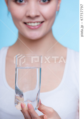 Woman holding a glass of water 47757797