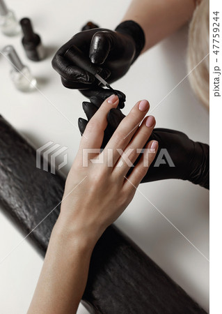 Manicurist in black gloves, causes the client 47759244