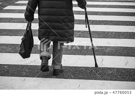 aged woman walking with stick in the street aged woman walking with stick in the street 47760053