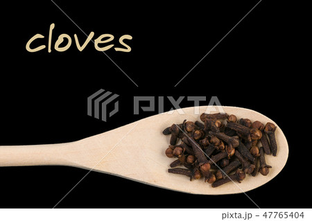 cloves on wooden spoon isolated on black backgroun 47765404