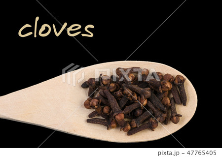 cloves on wooden spoon isolated on black backgroun cloves on wooden spoon isolated on black backgroun 47765405