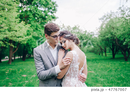 Bride and groom in a park hugging 47767007