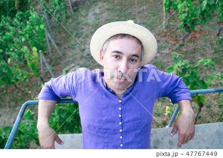 Portrait of man in straw hat sitting on bench 47767449