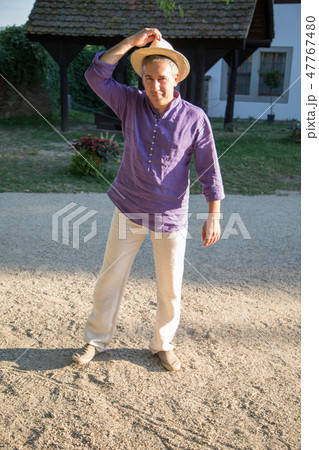 Happy man in straw hat near village house Happy man in straw hat near village house 47767480