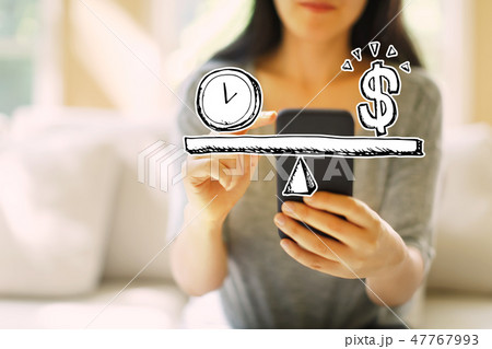 Time and money on the scale with woman using a smartphone Time and money on the scale with woman using a smartphone 47767993
