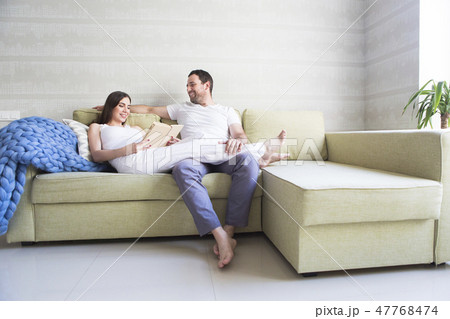 Pregnant woman and young man together indoors 47768474