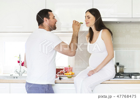 Pregnant woman and happy man in the kitchen 47768475