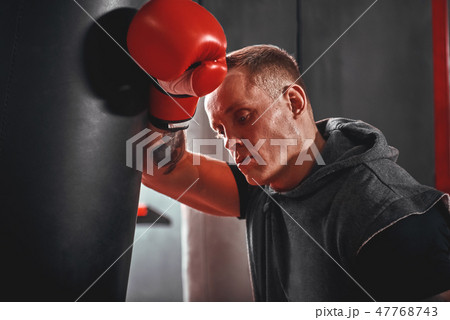 Tired after workout. Tired young athlete in sports clothing looking away after hard training on 47768743