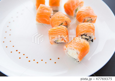 Sushi roll with salmon, philadelphia on a white plate, top view. Close-up. Beautifully decorated 47769375