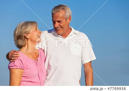 Happy Senior Couple Walking Embracing in Blue Sky 47769938