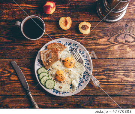 Toast with fried eggs, vegetables and coffee 47770803