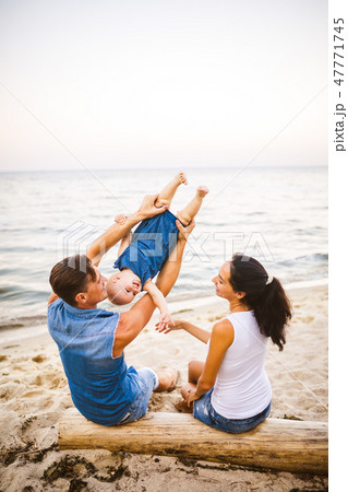 Theme family weekend, beach summer vacation with child. Young stylish family of three dad mom and 47771745