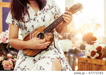 Happy woman musician playing ukulele in studio. Happy woman musician playing ukulele in studio. 47773783