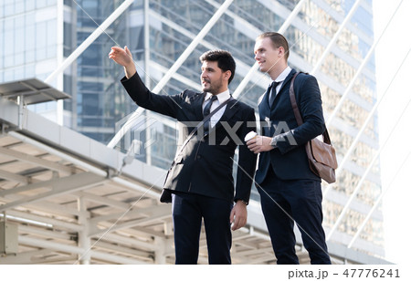 Two young business man talking to each other while 47776241