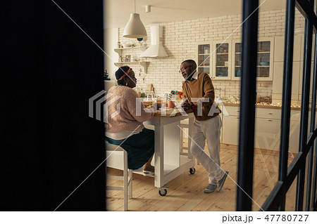 Nice pleasant couple talking in the kitchen Nice pleasant couple talking in the kitchen 47780727